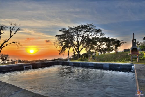 Sunset over infinity pool at Le Domaine De L'ilet cottage in Saint-Claude, Guadeloupe with sea view