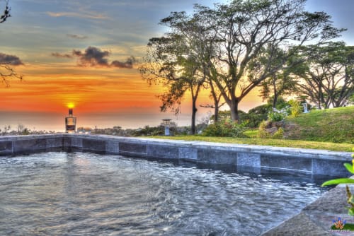 Sunset view from Le Domaine De L'ilet pool in Saint-Claude, Guadeloupe with tropical trees and sea view
