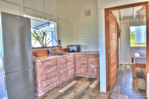 Modern kitchen in Kaz'Passiflora cottage at Le Domaine De L'ilet, Saint-Claude, with stainless steel refrigerator and