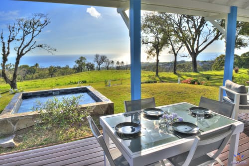 Le Domaine De L'ilet cottage terrace in Saint-Claude, Guadeloupe with dining table, pool, and sea views