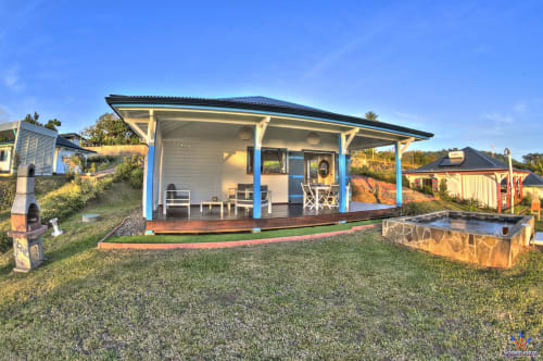 Kaz'Passiflora cottage at Le Domaine De L'ilet, Saint-Claude with blue columns, wooden deck and tropical garden