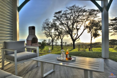 Sunset patio at Le Domaine De L'ilet cottage in Saint-Claude, Guadeloupe with lounge chair and valley views