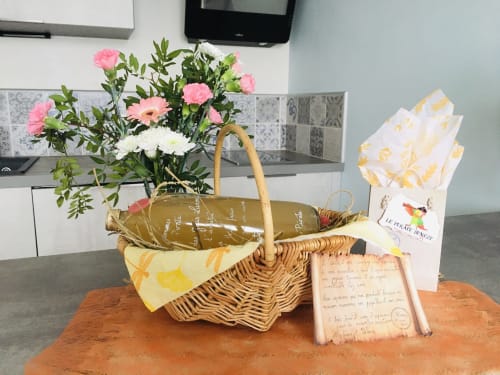 Panier de bienvenue avec fleurs roses, bouteille de vin et lettre française à la maison d'hôtes Le Pirate Benèze, Trizay