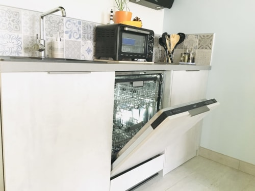 Kitchenette moderne au gîte Le Pirate Benèze à Trizay avec lave-vaisselle ouvert et étagère inox