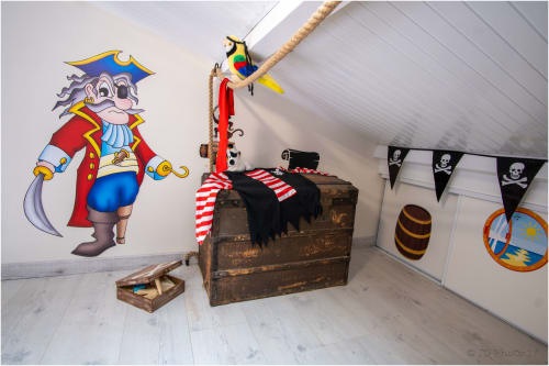 Chambre pirate aménagée en grenier au Gîte Le Pirate Benèze à Trizay, avec coffre au trésor, drapeaux de pirates et personnages colorés
