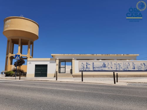 Guesthouse Ó da Casa à Peniche avec sa tour d'eau distinctive et fresque en azulejos portugais sur ciel bleu