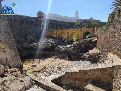 Ruines de forteresse historique en pierre avec pont jaune et bâtiments blancs à Peniche, Portugal - hébergement Ó da Casa