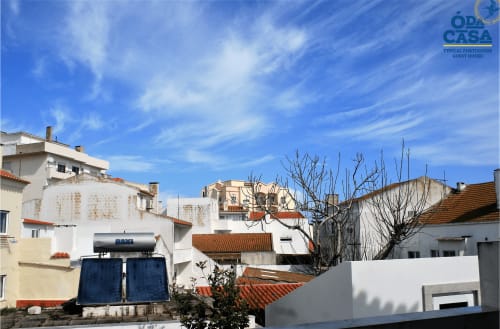 Guesthouse Ó da Casa à Peniche avec bâtiments blancs, toits en terre cuite et ciel bleu