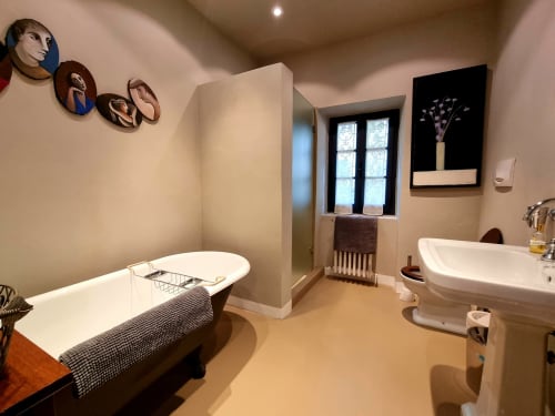 Luxury bathroom at Villa Italia with freestanding tub, modern sink, heated radiator, and framed artwork