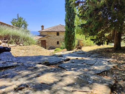 Rustic Italian stone villa with cypress trees and traditional architecture overlooking the sea