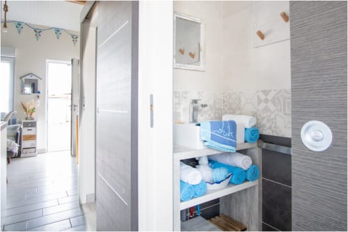 Salle de bains moderne au gîte Le Pirate Benèze à Trizay avec rangement bleu et carrelage contemporain