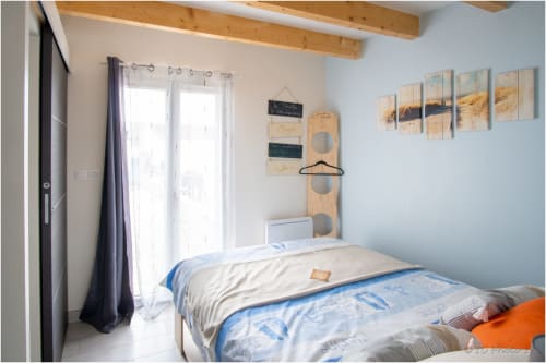 Chambre lumineuse au B&B Le Pirate Benèze à Trizay avec lits jumeaux, poutres en bois, décor côtier et art mural thématique balnéaire.