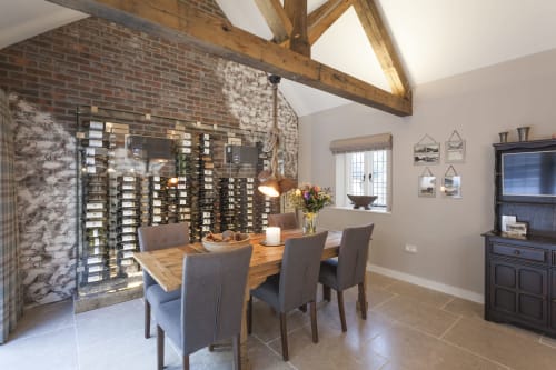 Sala da pranzo moderna della cantina dell'hotel Three Little Pigs a Blandford Forum con travi in legno e tavolo di degustazione
