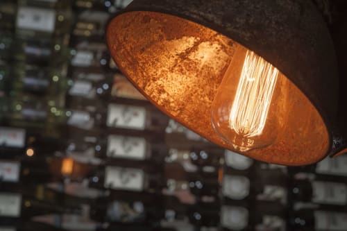 Lampadina Edison vintage che illumina un'elegante lampada in rame caldo nell'hotel Three Little Pigs a Blandford Forum