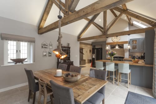 Cucina a pianta aperta e sala da pranzo presso Three Little Pigs con travi a vista, tavolo in legno e servizi moderni a Blandford