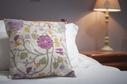 Cuscino floreale decorativo sul letto dell'hotel Three Little Pigs a Blandford Forum con lampada da comodino