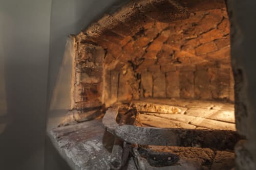 Interno del forno in laterizio storico dell'hotel Three Little Pigs a Blandford Forum, con travi in legno a vista