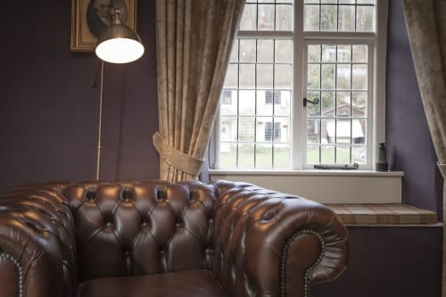 Divano Chesterfield in pelle vicino alla finestra presso l'hotel Three Little Pigs, Blandford Forum