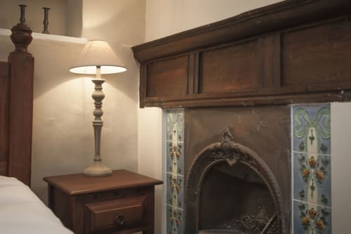 Camera dell'hotel Three Little Pigs con lampada da comodino, comodino in legno e camino decorativo a Blandford Forum