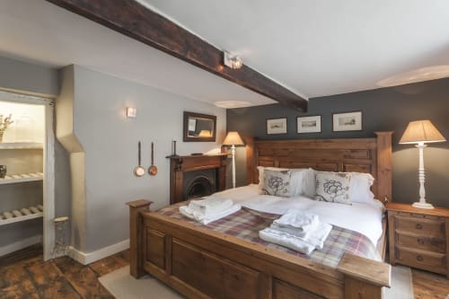 Camera accogliente dell'hotel Three Little Pigs a Blandford Forum con letto in legno, camino e travi a vista