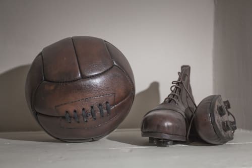 Pallone e stivali da calcio vintage esposti nell'hotel Three Little Pigs a Blandford Forum