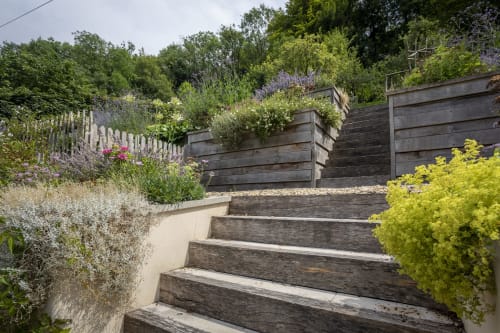 Gradini da giardino in legno con bordure fiorite all'hotel Three Little Pigs di Blandford Forum