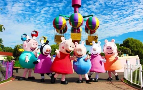 Peppa Pig characters at Three Little Pigs theme park in Blandford Forum with colorful hot air balloons