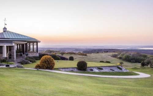 Three Little Pigs hotel gazebo overlooking Blandford Forum countryside at sunset with manicured gardens