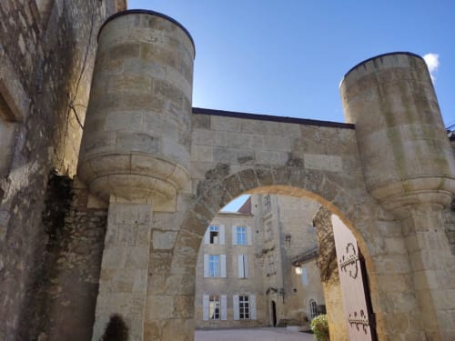 Medieval stone gateway with twin towers at Le Rêve d'Alice, a charming bed and breakfast in Saint-Puy, France
