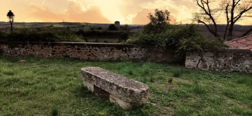 Ancient stone bench overlooking countryside at Le Rêve d'Alice, a charming bed and breakfast in Saint-Puy, France.