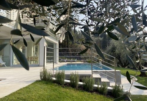 Vista della piscina del Verdolivo B&B con rami d'olivo, terrazza moderna e paesaggio del Lago d'Iseo a Sale Marasino