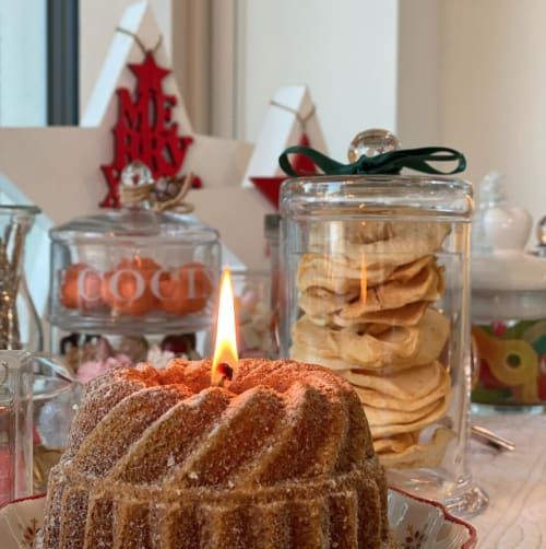 Tavola festiva allestita a Verdolivo B&B con candela accesa, pasticcini e decorazioni natalizie