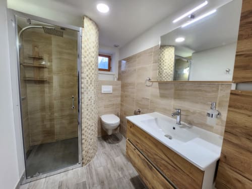 Modern bathroom with walk-in shower, double sink vanity, and wooden accents at Domaine à l'Aise cottage in Saint-Pargoire