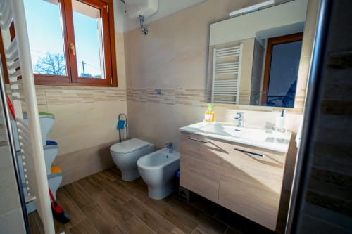 Bagno moderno di La Casetta di Pietra B&B a Gavorrano con vanità, toilet, bidet e pavimento in legno