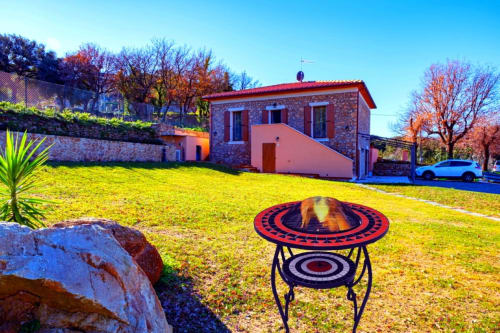 Vista del giardino presso La Casetta di Pietra B&B a Gavorrano, Italia, con un camino decorativo con motivo rosso e nero