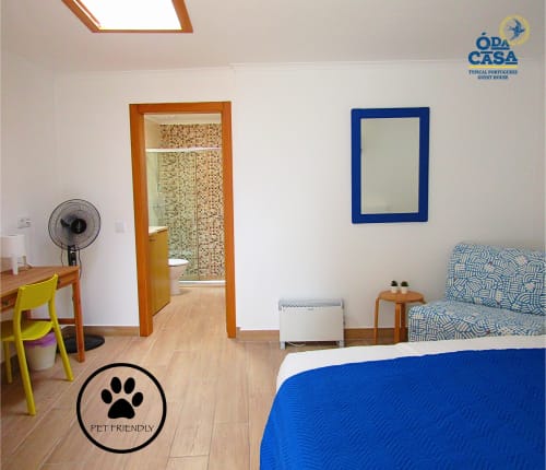 Quarto pet-friendly na pousada Ó da Casa em Peniche com detalhes em azul, escrivaninha e casa de banho privativa