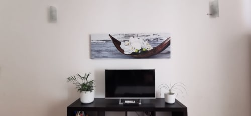 Modern entertainment setup in Casa Bellini Palermo apartment with flat-screen TV, plants, and artistic boat canvas above
