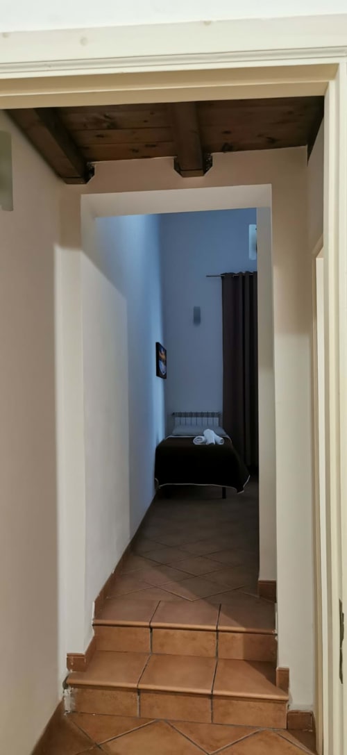 Hallway entrance to Primo Apartment at Casa Bellini in Palermo, leading to bedroom with blue walls