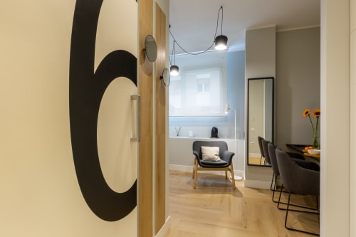 Camera moderna a Casa Lounge Istria Cagliari con specchi contemporanei, lampade a sospensione, pavimenti in legno e vista sulla città