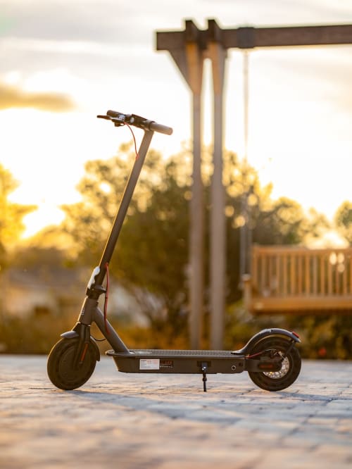 Trottinette électrique garée à la location Belle Île en mer avec pergola et coucher de soleil