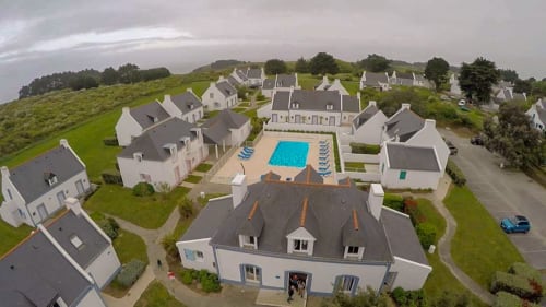 Vue aérienne du resort Loc'Maria à Belle-Île-en-Mer avec cottages blancs, piscine et espaces verts