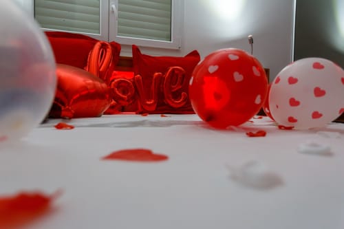 Décoration romantique pour la Saint-Valentin avec ballons rouges et confettis en cœur au Kaz A Bibi B&B à Sainte-Rose