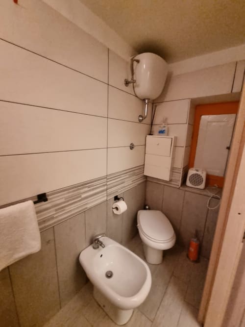 Small bathroom in Majorana apartment at B&B Il Conservatorio Naples with bidet, toilet, sink, and wall-mounted water heater