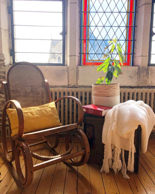 Chambre douillette à La Maison D'olivier avec chaise berçante, plante en pot et vue sur des monuments depuis les fenêtres