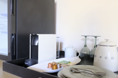 Modern kitchen setup at Villa Várzea B&B with coffee machine, white kettle, glasses, and place setting in Várzea, Portugal