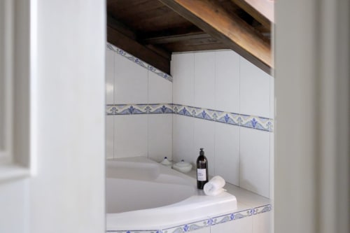 Bathroom niche with white tiles, blue decorative border, and bath essentials at Villa Várzea, Várzea Portugal