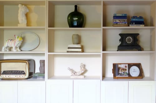Styled shelving display at Villa Várzea bnb in Várzea featuring decorative objects, books, vintage items, and collectibles