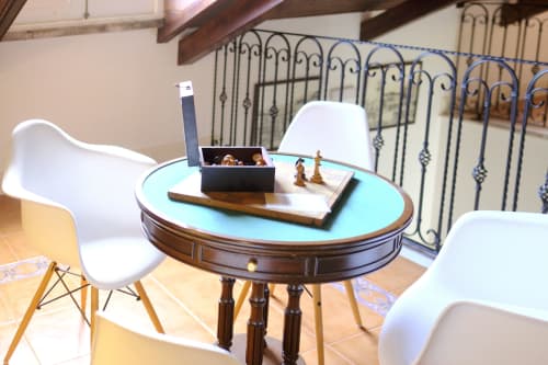 Modern seating area at Villa Várzea with white chairs around turquoise table and decorative items in Várzea, Portugal