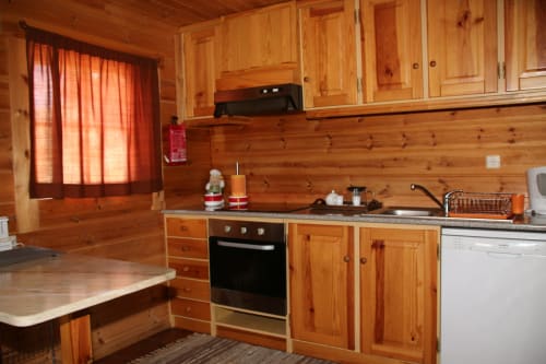 Cozinha da cabana com armários de pinho, sala de jantar e fogão no chalé Cota 1500, Penhas da Saúde