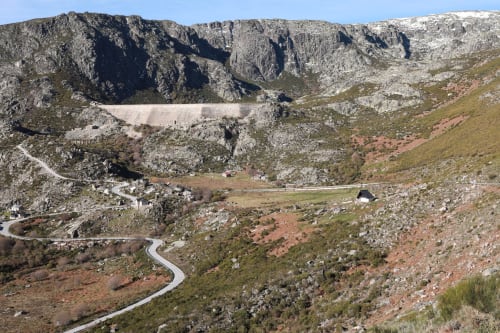 Vale montanhoso com estrada sinuosa, barragem e picos rochosos no hotel Cota 1500, Penhas da Saúde Portugal